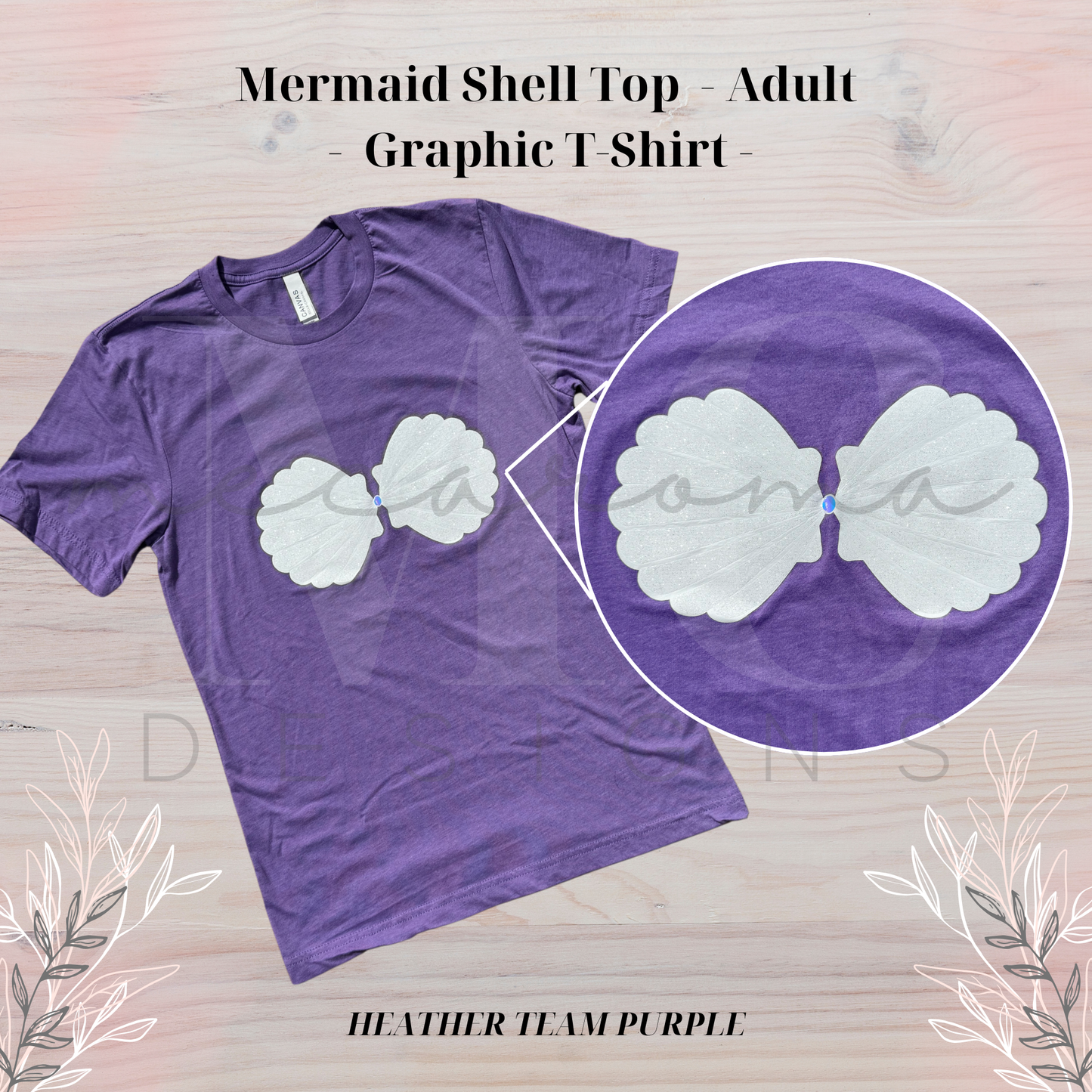 Heather team purple adult t-shirt with a graphic of a white mermaid shell bra top across the chest, shown on a light wood background with floral accents and a close-up inset of the shell design.